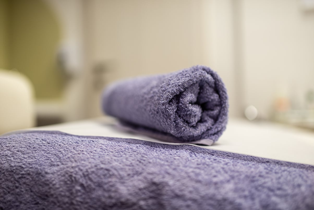 Rolled Purple Towel on Massage Table