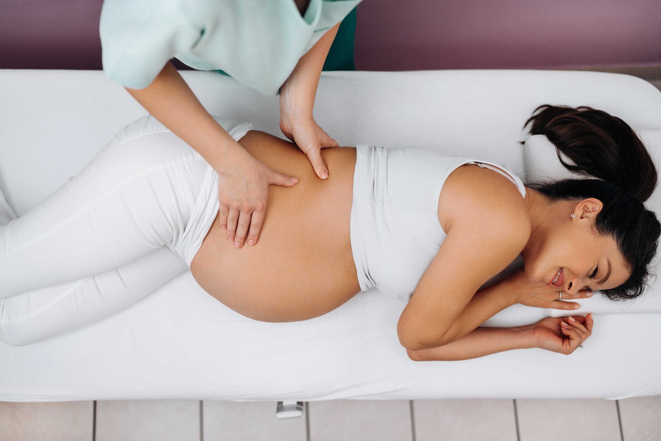 Therapist Massaging the Back of a Pregnant Woman